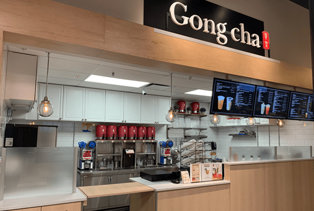 Interior image of wood Gong cha counter with black sign and menu boards