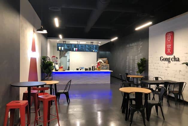 Image of interior Gong cha store with white and gray wall and black and red chairs