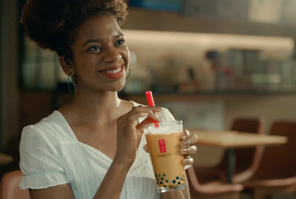 Image of woman in white shirt drinking bubble tea