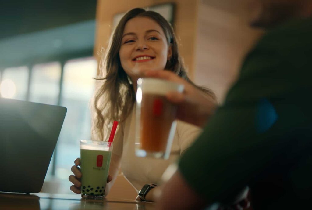 Image of girl smiling and holding a drink